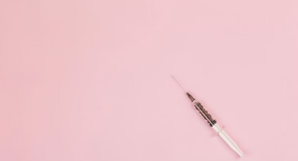 Minimal syringe on a blush background