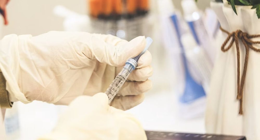 Gloved practitioner preparing a treatment